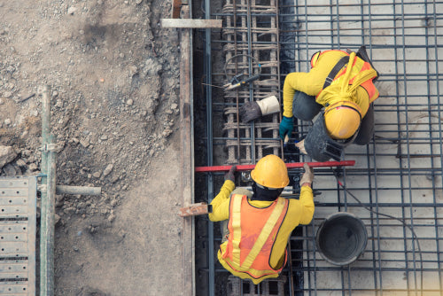 demonstrating safety workers on a construction site with their branded hard hats